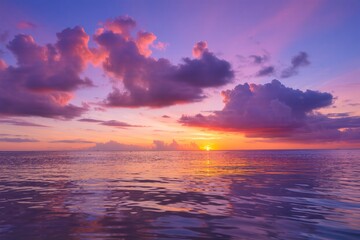 Dramatic orange and red sunset over the tranquil sea with clouds and sunlight on the horizon
