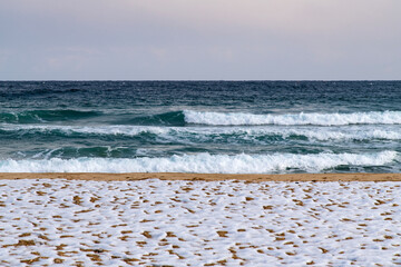 tranquil seascape with snow-covered beach and waves