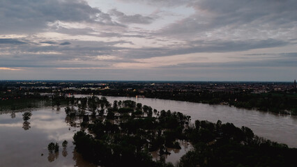 Serene evening sky over flooded landscape at Castelvetro Piacentino reflecting the twilight in the calm waters of the Po River creating a peaceful natural panorama