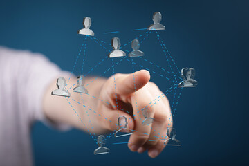 Hand points to a network of connected people, symbolizing global communication and teamwork.