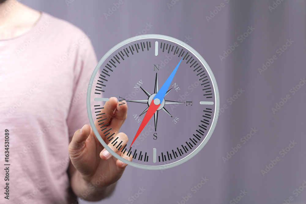Poster stock photo of a person interacting with a digital compass, showing navigation and direction finding