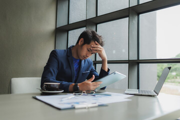 Male office worker overwhelmed by deadlines, staring at screen in frustration.