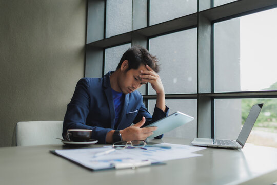 Male office worker overwhelmed by deadlines, staring at screen in frustration.