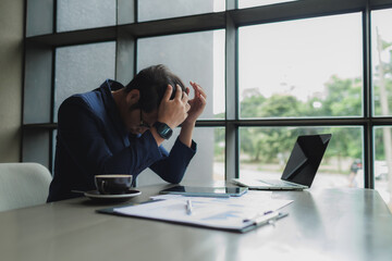 Male office worker overwhelmed by deadlines, staring at screen in frustration.