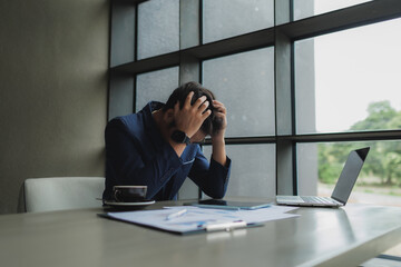 Male office worker overwhelmed by deadlines, staring at screen in frustration.