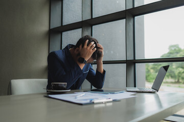Male office worker overwhelmed by deadlines, staring at screen in frustration.