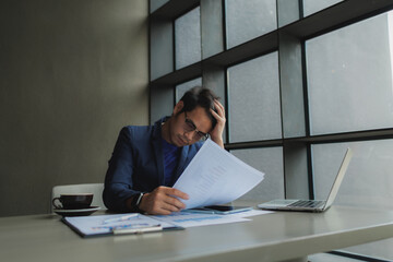 Male office worker overwhelmed by deadlines, staring at screen in frustration.