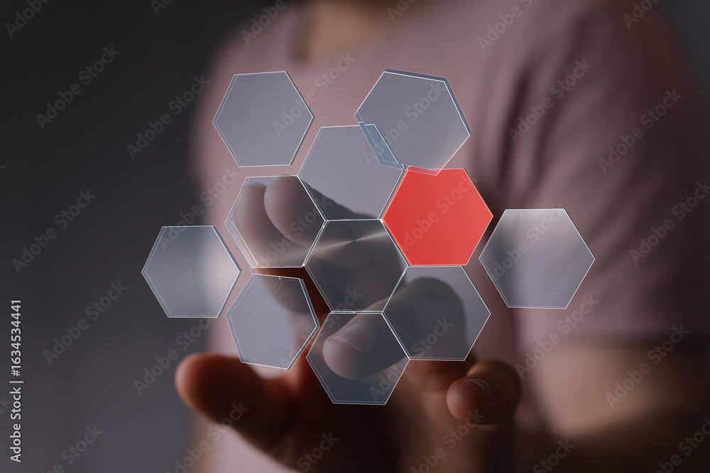 Poster person interacting with a digital hexagon interface, highlighting a key data point.
