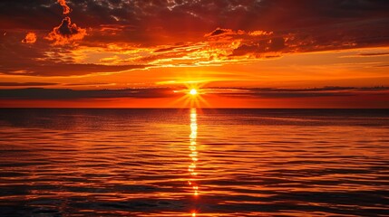 Stunning orange and red sunset over calm ocean, sun's reflection on water, dramatic sky