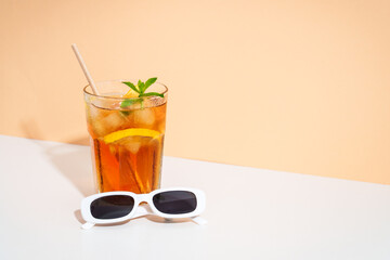 Summer iced cocktail drink with sunglasses and sunny shadows.