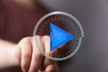 Abstract image of a hand interacting with a digital play button interface.