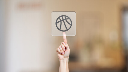 Finger Pointing to Basketball Icon on Transparent Interface for Sports Application or Game Selection with Blurred Background