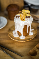 Traditional Easter cakes (kulich) with icing, dried fruits, and nuts on rustic background. Homemade sweet bread, festive pastry for Orthodox Easter, decorated with eggs and spring details.