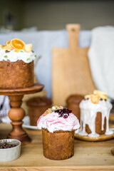 Traditional Easter cakes (kulich) with icing, dried fruits, and nuts on rustic background. Homemade sweet bread, festive pastry for Orthodox Easter, decorated with eggs and spring details.