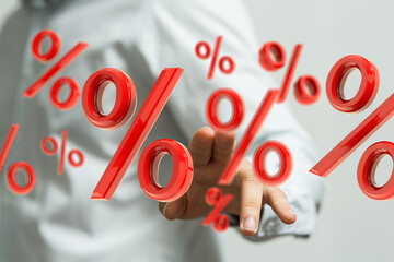 Image of red percentage symbols floating in a person's hand, representing discounts, sales,...