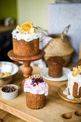 Traditional Easter cakes (kulich) with icing, dried fruits, and nuts on rustic background. Homemade sweet bread, festive pastry for Orthodox Easter, decorated with eggs and spring details.