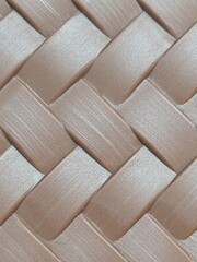 A flat weave pattern, resembling alternating strips stacked crisscrossing each other. A soft light brown or copper color, with a semi-glossy surface, resembling a brushed texture. It resembles a synth