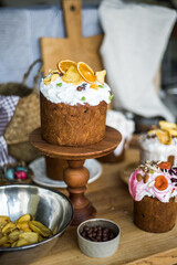 Traditional Easter cakes (kulich) with icing, dried fruits, and nuts on rustic background. Homemade sweet bread, festive pastry for Orthodox Easter, decorated with eggs and spring details.