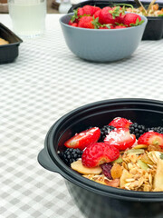Healthy takeaway meals in lunch boxes with vegetables, fruits, and rice. Outdoor picnic, eating in car, casual food to-go, fitness meals, eco packaging, lifestyle food photography.
