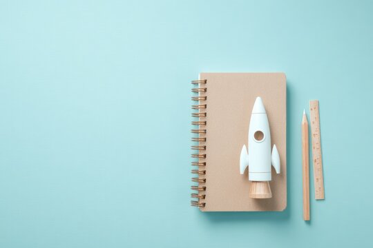 Notebook features rocket model with minimalist design on soft bl