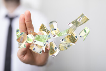 Image of a businessman rejecting flying euro banknotes.  Financial refusal, loss, or rejection...