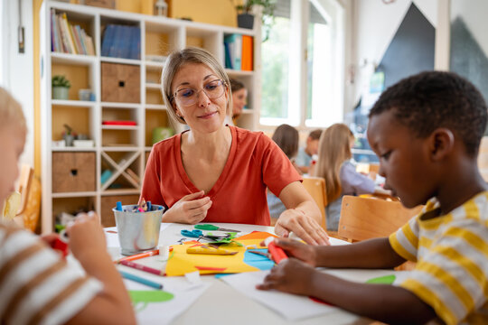 Preschool teacher interacting with a diverse group of children during an arts and crafts activity, fostering creativity and multicultural learning.
