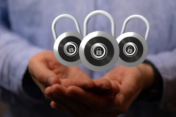 Image of three padlocks over open hands symbolizing data security, online safety, and privacy...