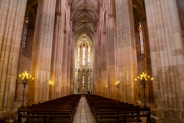Fototapeta premium The soaring nave and intricate ribbed vault ceiling of the magnificent Batalha Monastery church in Batalha, a masterpiece of Gothic architecture. Portugal