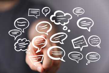 Hand pointing at a screen showing multiple speech bubbles, representing communication and ideas.