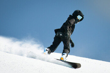 Close up front view woman snowboarder wear black outfit on piste ski downhill fast motion in Alps....