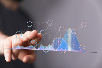 Stock photo of a hand interacting with a digital graph showing data analysis and visualization.