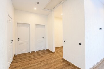 hallway with a neutral color palette, focusing on whites, light grays, and browns. The walls are painted in a soft, light gray lavender tone, adding a subtle hint of color