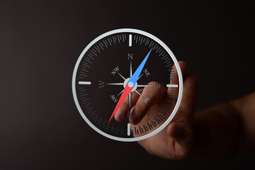 A hand interacts with a digital compass, illustrating navigation, direction, and guidance.