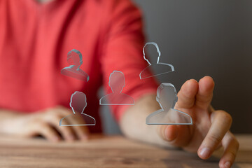 Person interacting with digital employee profiles.  Teamwork, collaboration, HR tech.