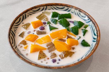 angle view bowl of coconut milk chrysanthemum mango jelly