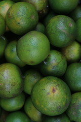 Fresh Green Oranges Close-Up Close-up view of fresh green oranges piled together, perfect for fruit, agriculture, and food market themes.