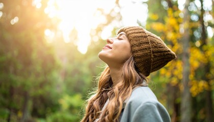 A serene woman wearing a knitted hat enjoys the warmth of sunlight in a peaceful forest setting, embodying tranquility and connection with nature.