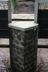 Rustic Stone Pillar at Park Entrance Close-up of a rustic stone pillar at a park entrance, showcasing textured stonework and countryside architecture.
