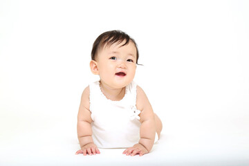 白背景の前をハイハイする赤ちゃんの正面クローズアップ。斜め上目線