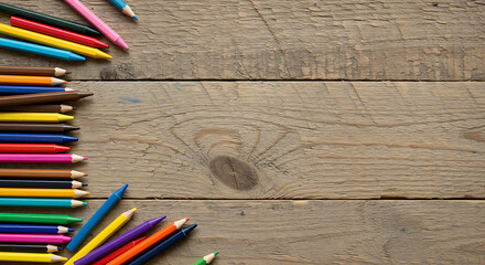 Arrangement of colored pencils in a spectrum of hues against a rustic wooden plank backdrop.