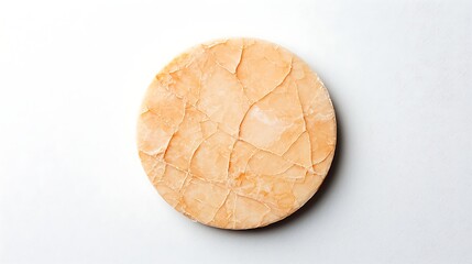 A round, cracked surface with a light orange hue, resembling a piece of natural stone or mineral, set against a plain background.