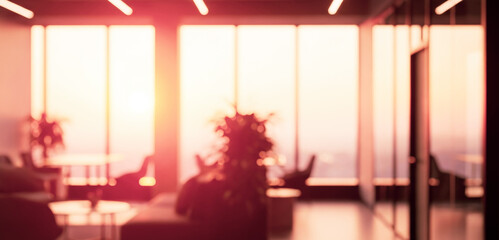 Blurred office interior with large windows and sunlight streaming in, highlighting open space layout and enhancing the tranquil atmosphere of a modern workspace.