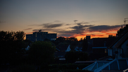 Sunset sky city town evening dusk twilight cloud silhouette building roof orange red beautiful...