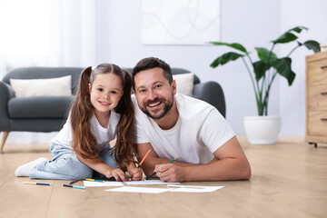 Father and daughter feeling comfortable on warm floor at home. Underfloor heating