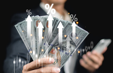 Businessman holding money with arrow icon pointing up, property rates and real estate interest,...