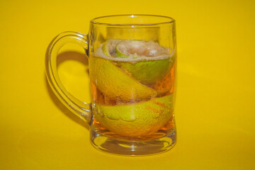 Glass Mug of Lemon Beer with Ice on Yellow Background