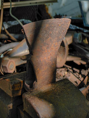 An antique, rusty axe head rests on an anvil, showcasing rustic tools and craftsmanship.