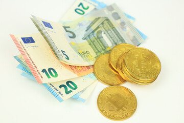 Bitcoins and Euro bills on white background