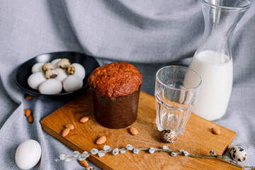 Fototapeta premium Traditional Easter cakes (kulich) with glaze, nuts, and dried fruits. Rustic still lifes with milk, eggs, willow branches, gift boxes, and festive decorations for Orthodox Easter celebration.