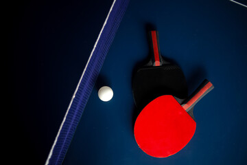 Tennis racket and ball on ping-pong table with net prepared for game